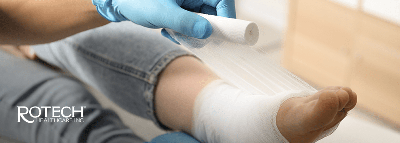 Leg with wound that is covered by white wrap.