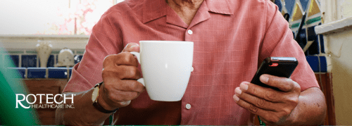 Man holding coffee cup and using his smartphone